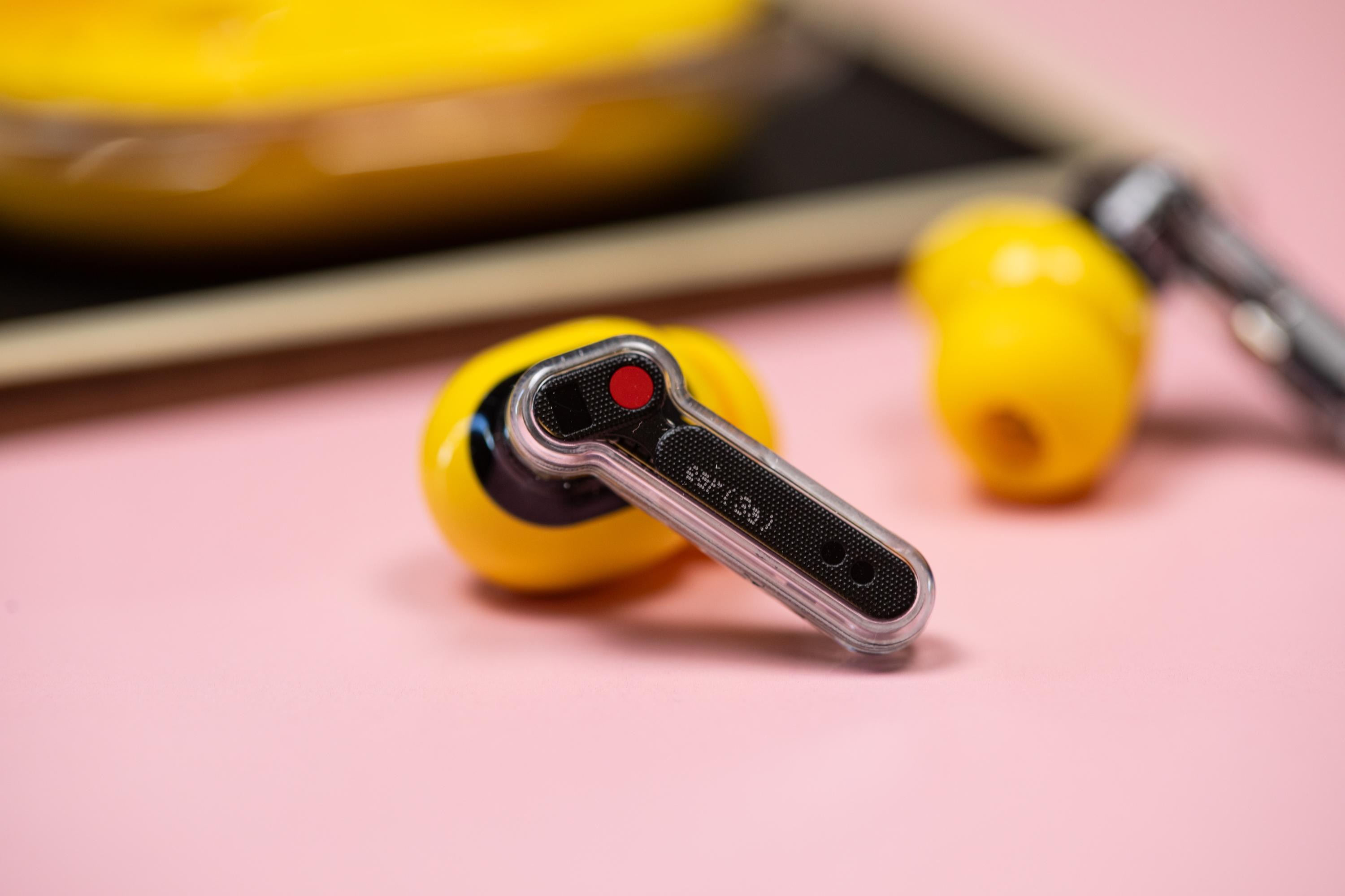 The Nothing Ear 3A earbuds on a mauve background with their case.