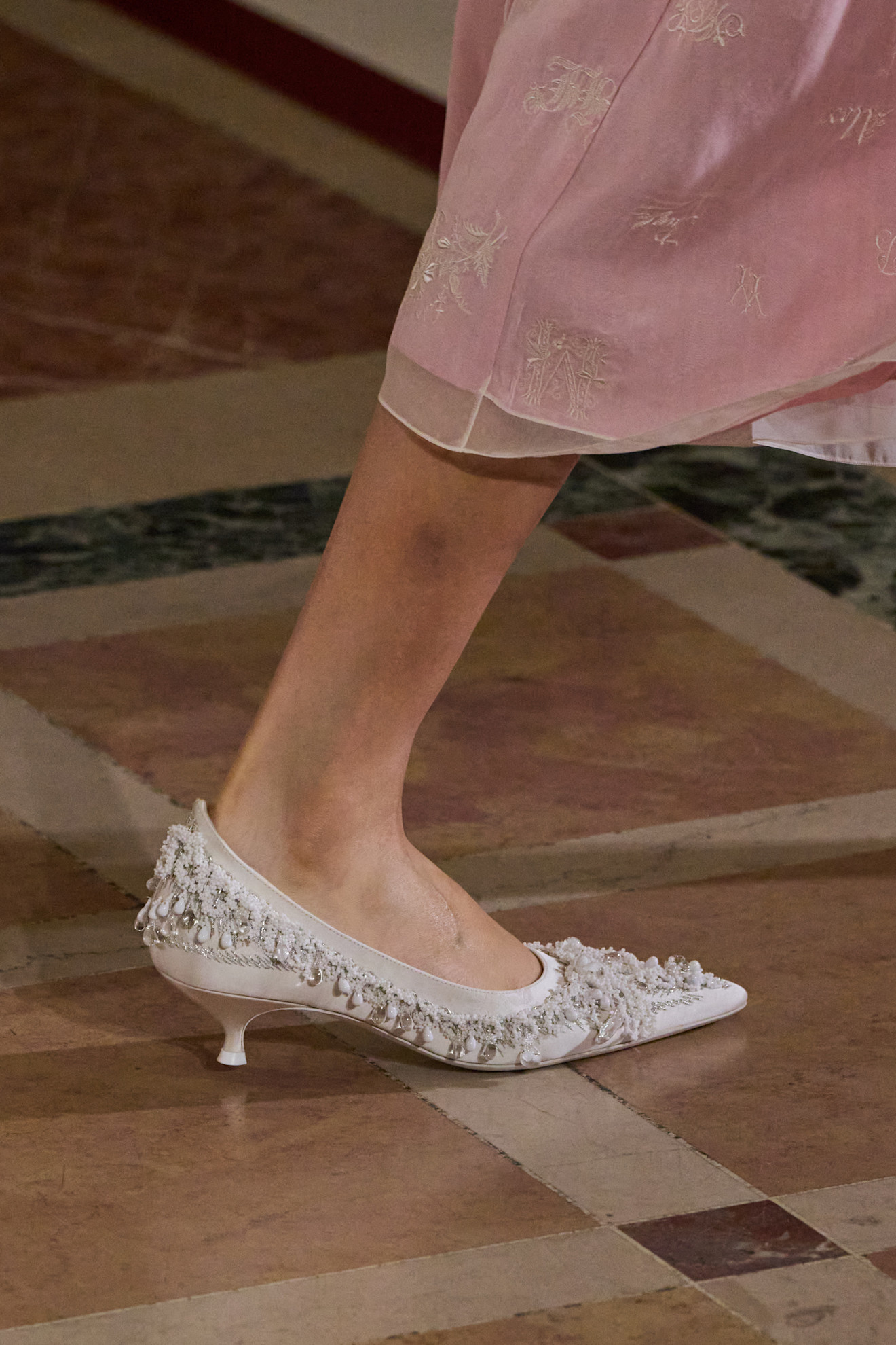 A close-up image of Tory Burch's S/S 26 white beaded pumps.