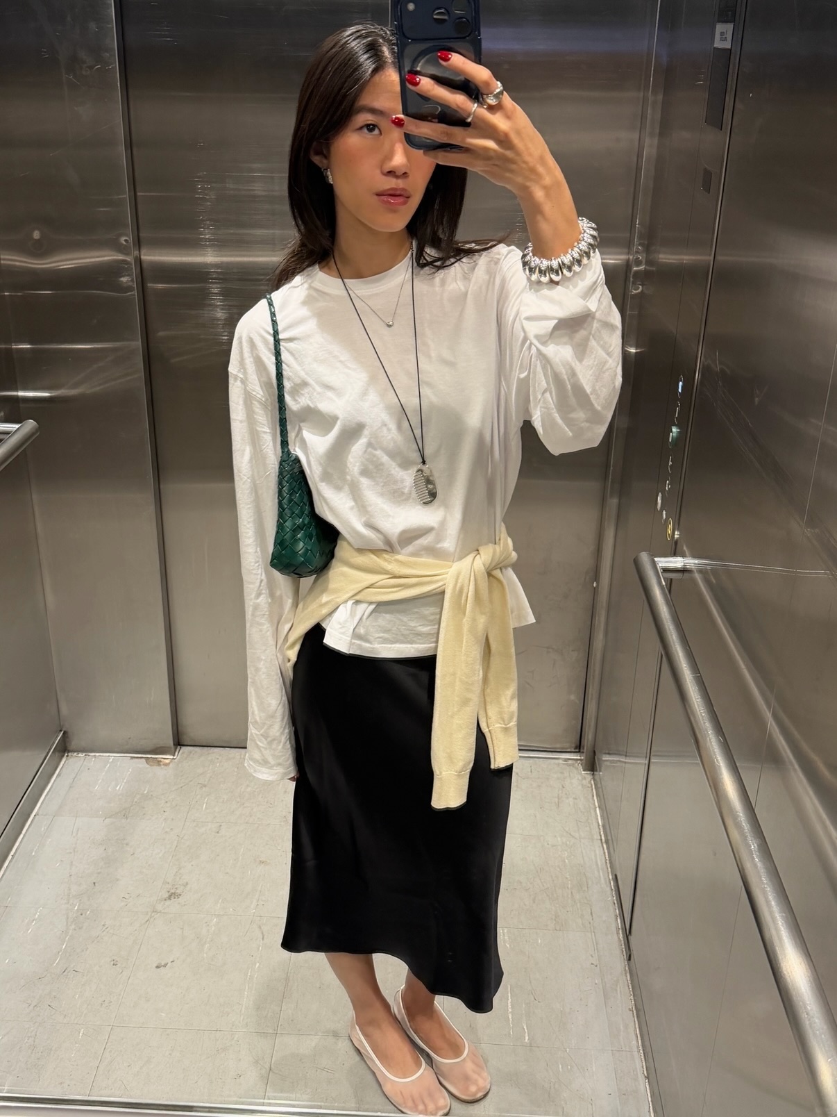 An image of @hidings wearing mesh shoes with a pencil skirt, white long-sleeved shirt and a yellow jumper tied around her waist.